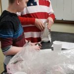 Students discover if a coat keeps a snowman from melting